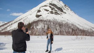 Молодой человек фотографирует девушку во время экскурсии по туристическому маршруту