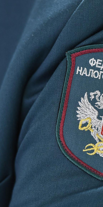 Гербовая нашивка на рукаве сотрудницы межрайонной инспекции Федеральной налоговой службы (ИФНС)