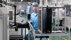 Работница цеха печатных плат проверяет работоспособность