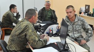Instruktоra-punkta-v-voyennoy-forme-muzhchiny-za-stolom