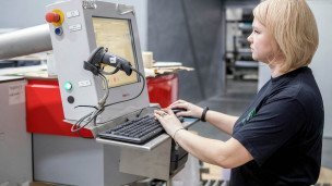 Оператор оборудования подбора цвета во время работы за компьютером