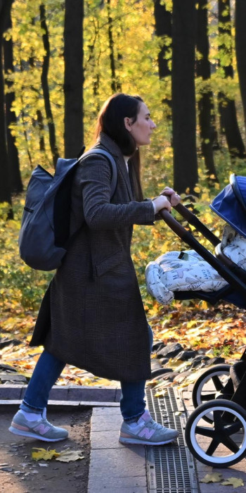 Женщина с коляской на прогулке