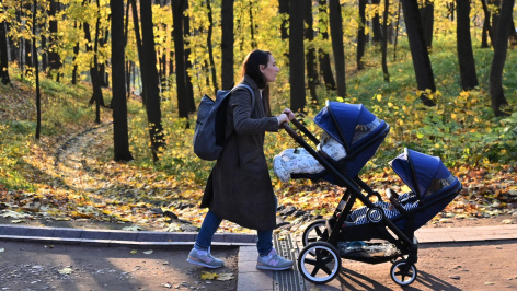 Женщина с коляской на прогулке