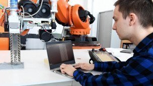 IT-специалист проверяет работоспособность робота для промышленных целей 