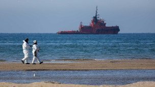 Волонтеры во время уборки пляжа от мазута