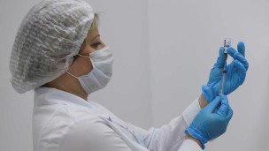 Медицинский работник набирает в шприц препарат
