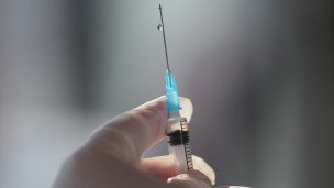 Шприц с вакциной в руках у медицинского работника