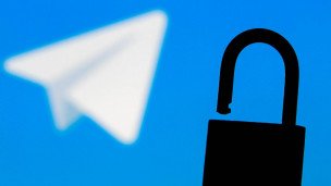 Логотип мессенджера Telegram на фоне, на переднем плане открытый амбарный замок