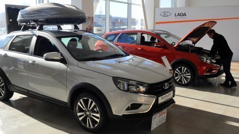 Посетитель рассматривает автомобиль 