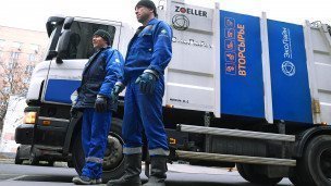 Сотрудники компании по сбору вторсырья на заднем плане грузовик