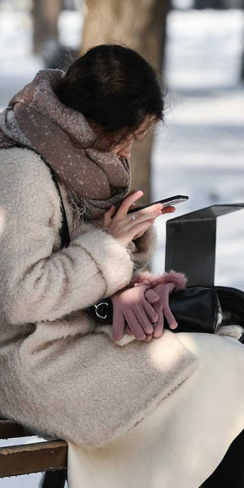 Девушка с телефоном в парке на лавочке