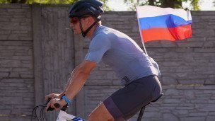 Велосипедист во время велопробега с флагом России