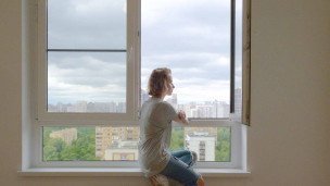 Девушка сидит у окна