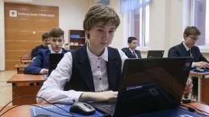 Ученица за ноутбуком в школьном классе
