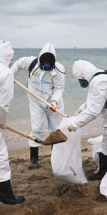 волонтеры собирают мазут на пляже
