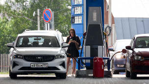 Женщина заправляет бензином автомобиль на АЗС