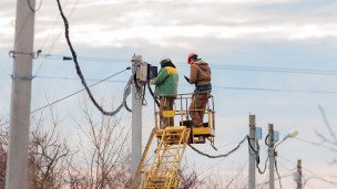 Сотрудники коммунальных служб ремонтируют линию электропередачи 