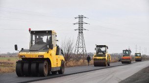 Сотрудники дорожно-строительной компании ремонтируют участок дороги