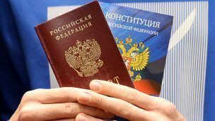 Молодой человек держит паспорт РФ