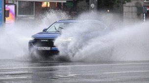 Автомобиль едет по лужам 