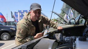 Осмотр моторного отсека на церемонии передачи автомобилей военнослужащим