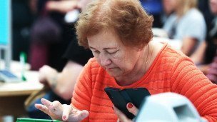 Пожилая женщина с планшетом и телефоном
