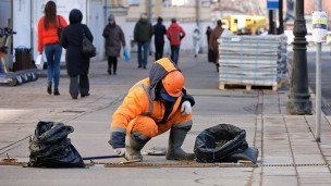 Сотрудник коммунальной службы во время ремонта дорожного покрытия на улице