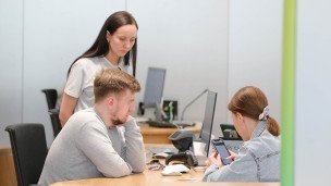 Сотрудница и посетитель в офисе отделения банка