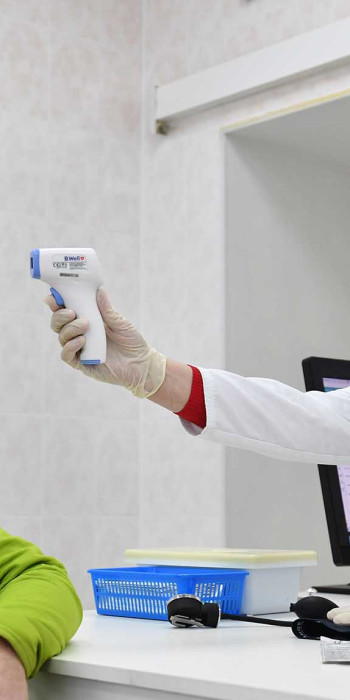 Врач измеряет температуру мужчине