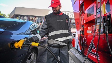 Мужчина заправляет бензин на заправке