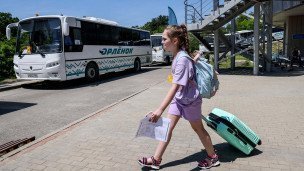 Девочка с чемоданом около автобуса на территории Всероссийского детского центра "Орленок"