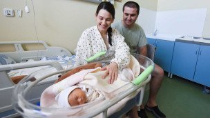 Молодые родители с новорожденным ребенком в палате