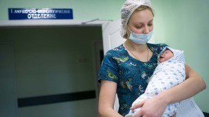 Врач с младенцем на руках