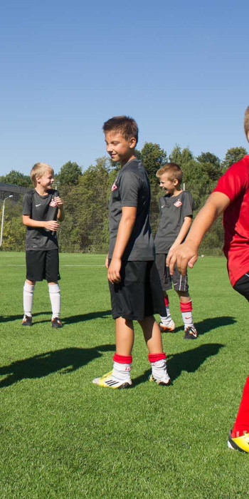 Юные футболисты на тренровочном поле футбольной школы