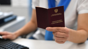 Сотрудник держит в руках пенсионное удостоверение