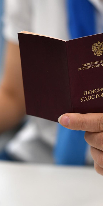 Сотрудник держит в руках пенсионное удостоверение