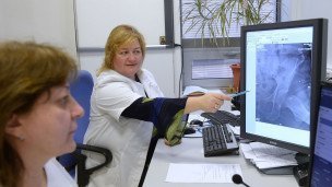 Медицинские сотрудницы смотрят на мониторе рентген пациента 
