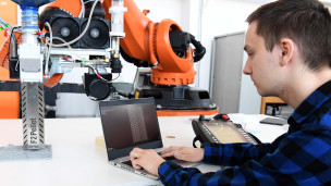 Студент проверяет работоспособность робота для промышленных целей 