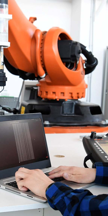 Студент проверяет работоспособность робота для промышленных целей 