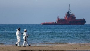 Волонтеры во время уборки мазута на берегу моря