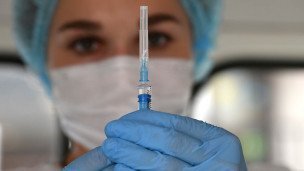 Медицинская работница держит шприц 