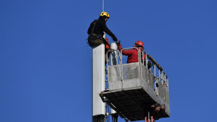 Рабочие монтируют базовую станцию сотовой связи