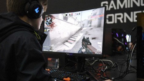 Ребенок играет в видеоигру за компьютером