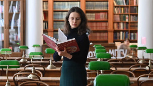 Студентка в библиотеке с книгой