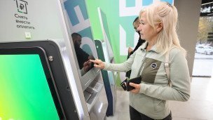 Женщина проводит денежные операции через современный банкомат 