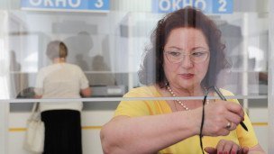 Женщина во время получения паспорта в миграционной службе МВД
