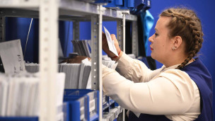 Сотрудница раскладывает письма в отделении Почты России