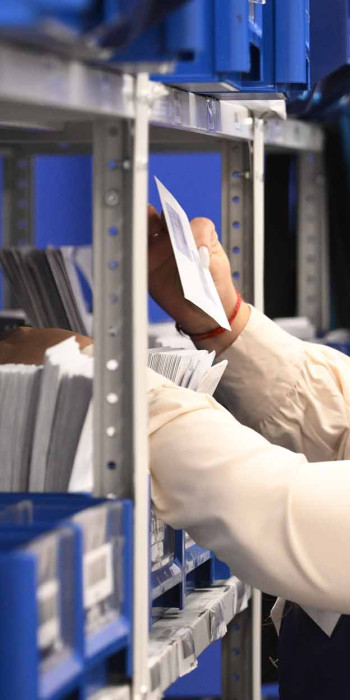 Сотрудница раскладывает письма в отделении Почты России