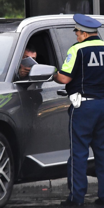 Сотрудник ДПС проверяет документы у водителя 