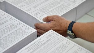Сотрудник типографии складывает напечатанные бюллетени для голосования